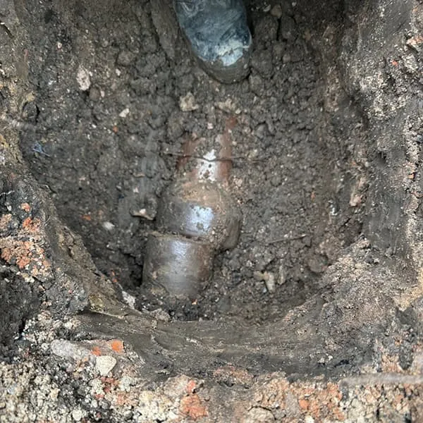 Excavated trench showing a collapsed underground clay drain pipe ready for expert structural repair by Drain Medics.